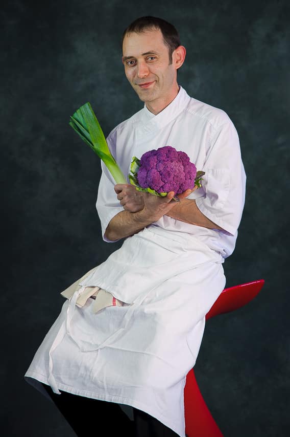 Portrait chef cuisinier avec chou et poireau dans les mains